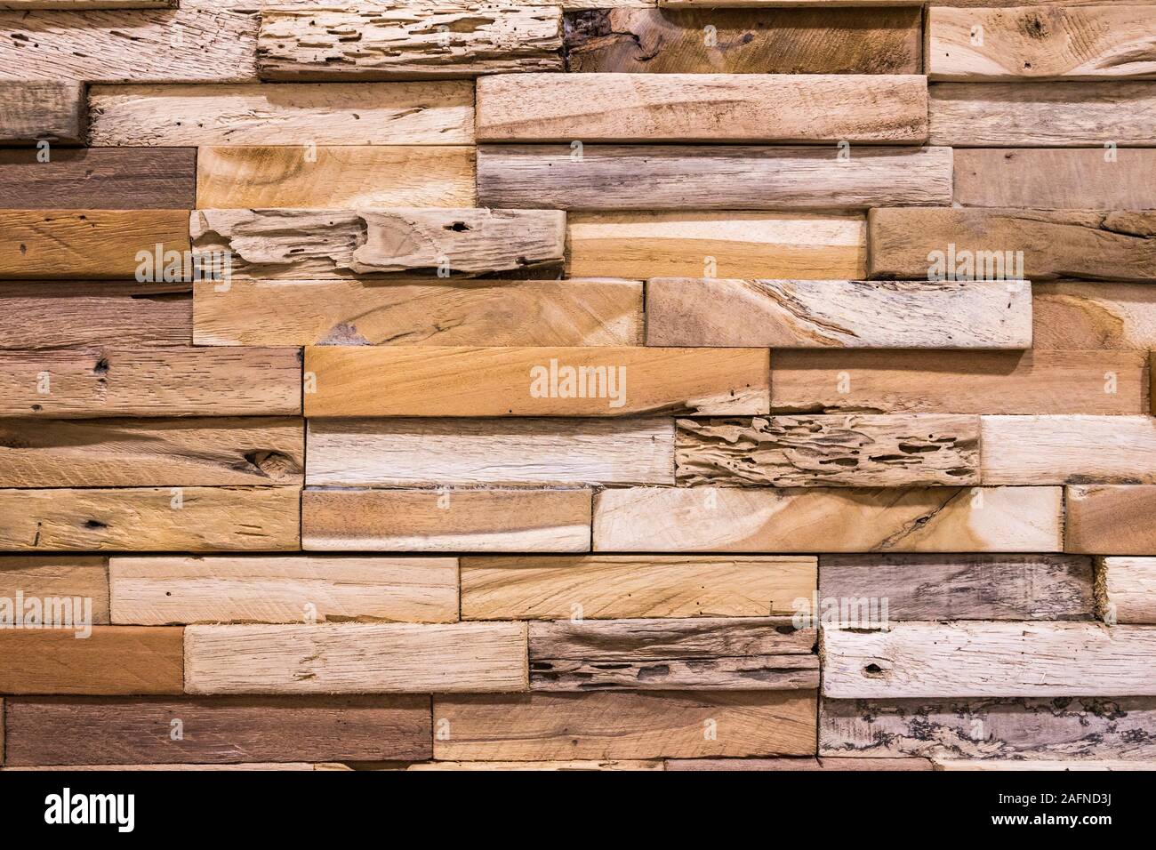 Piccoli mattoni di legno disposte insieme in una bella parete in legno per la decorazione di interni di edifici o di pavimenti e sfondi web,vecchia parete in legno Foto Stock