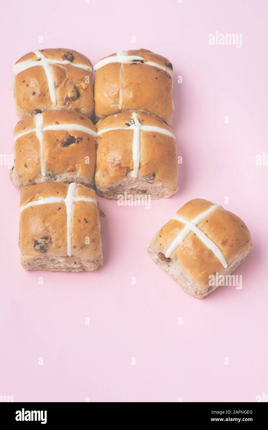Sei hot cross panini, britannica tradizionale cibo Pasqua su sfondo rosa, vista dall'alto, tonica, il fuoco selettivo Foto Stock