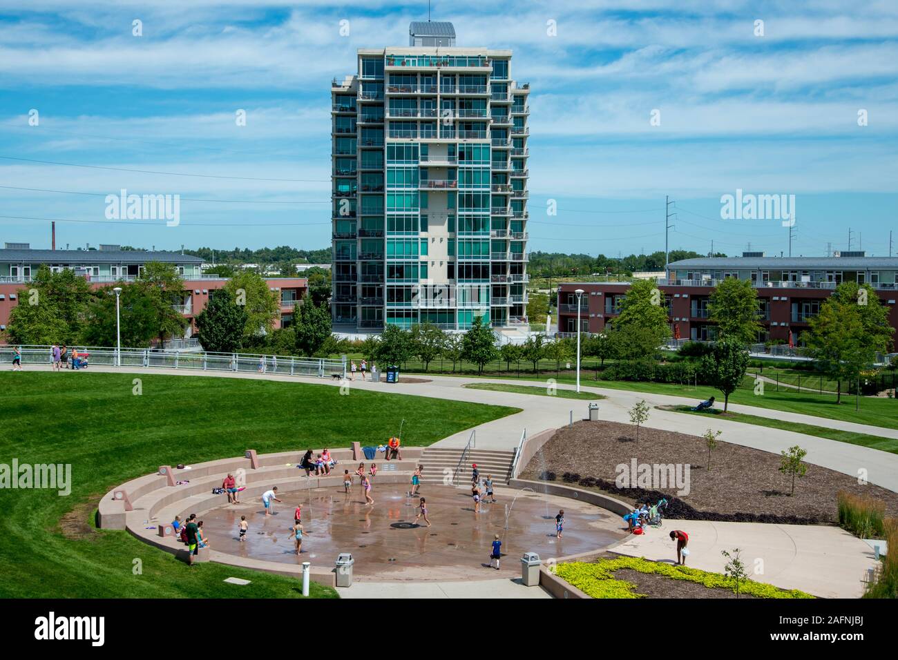 Omaha, Nebraska. Riverplace townhomes e condomini e mostrando persone aventi il divertimento a fontana di acqua in Omaha plaza. Foto Stock