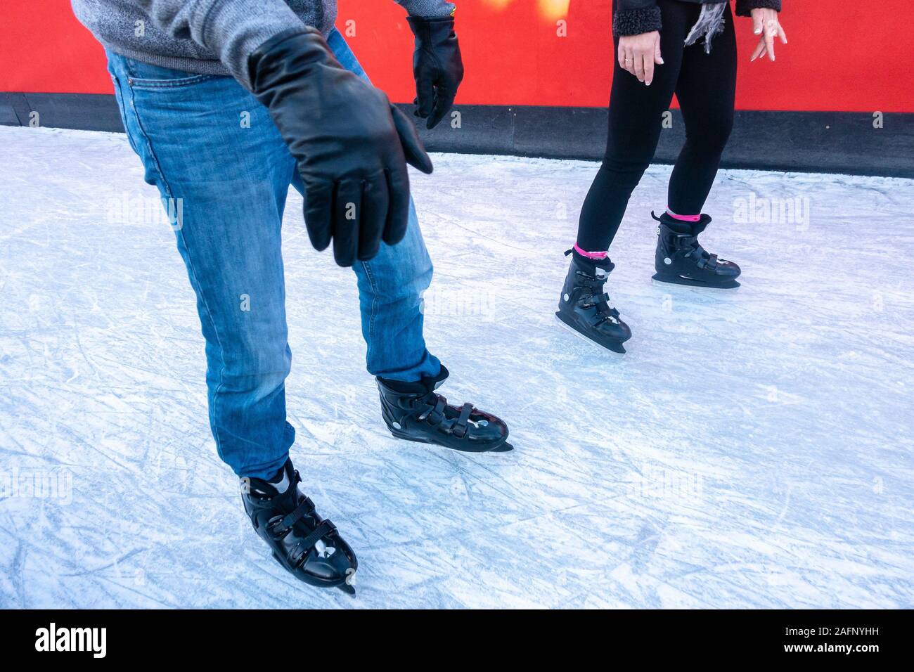 Un uomo e una donna il pattinaggio su ghiaccio. Solo le persone per le gambe e pattini da ghiaccio sul ghiaccio sono visibili. Foto Stock