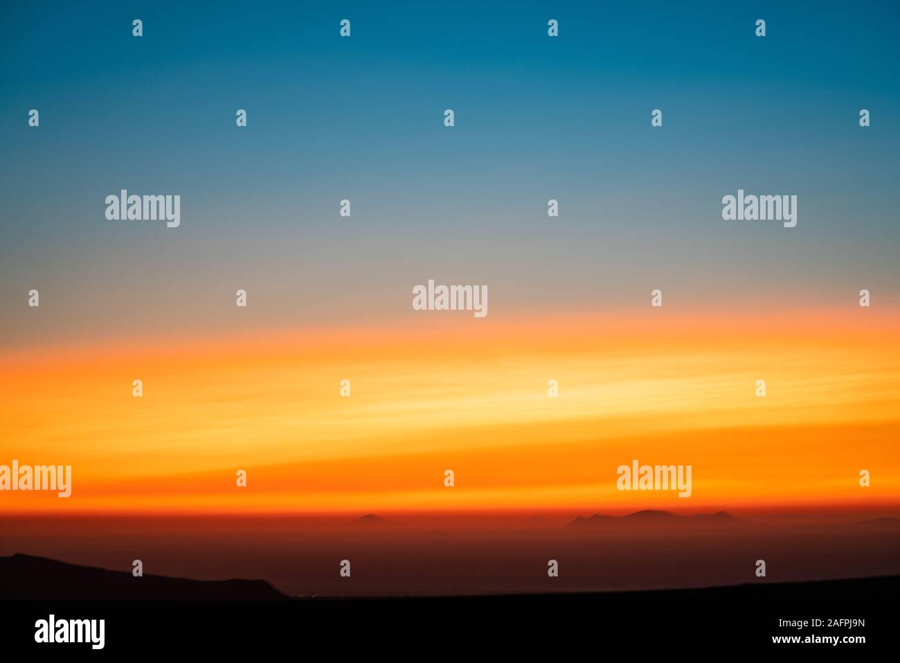 Abstract all'alba o al tramonto il concetto di sfondo blu per il colore arancione transizioni con lontane colline sagome . Foto Stock