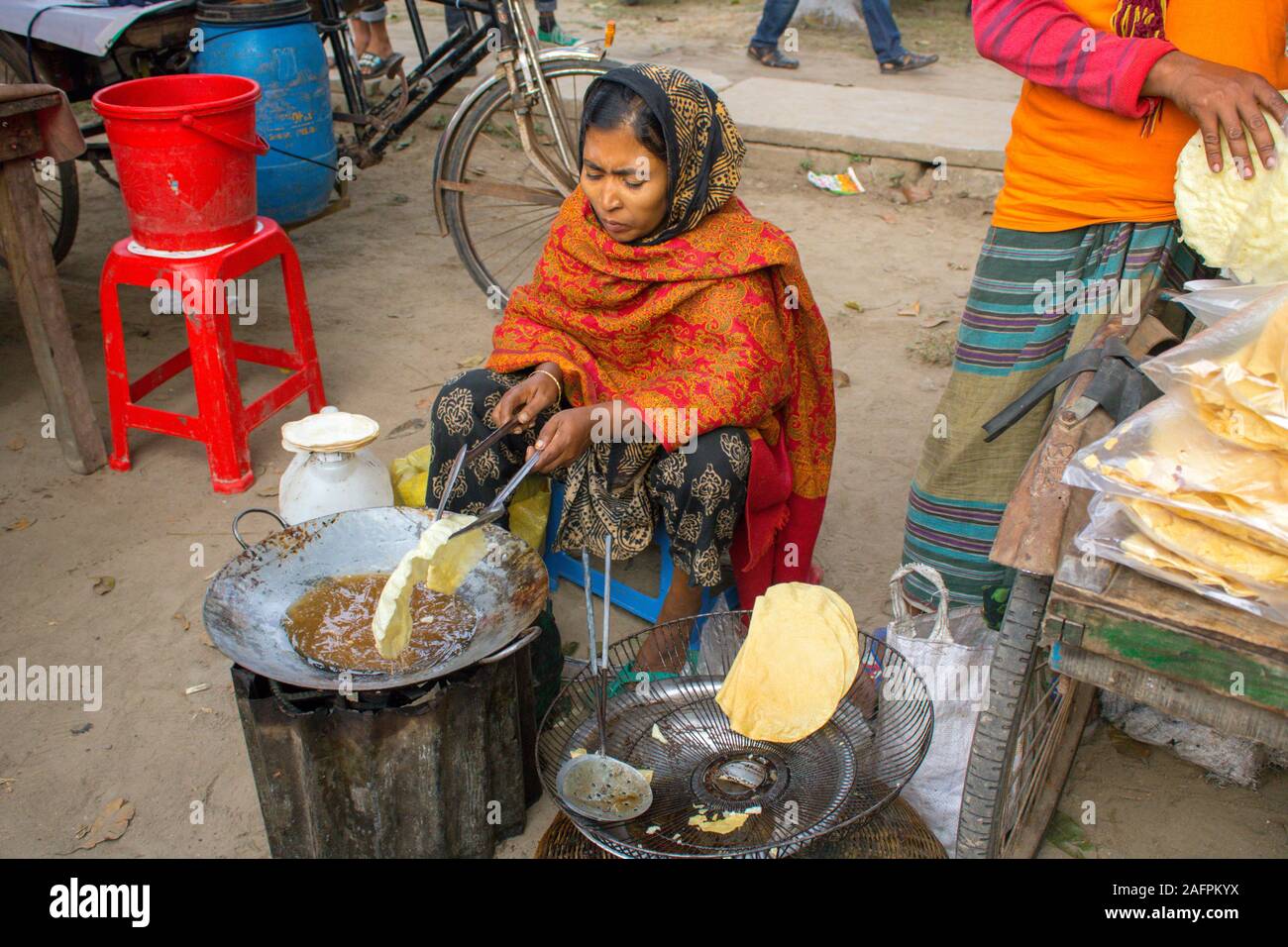 Una donna è friggere spuntini per la vendita nel giorno della vittoria evento Foto Stock