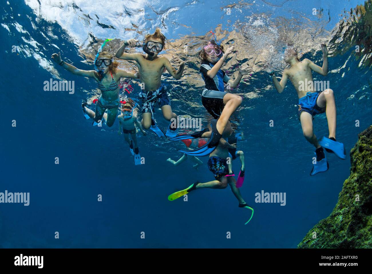 Adulto snorkeling con un gruppo di bambini nel mare Mediterraneo, l'isola di Zante, Grecia Foto Stock