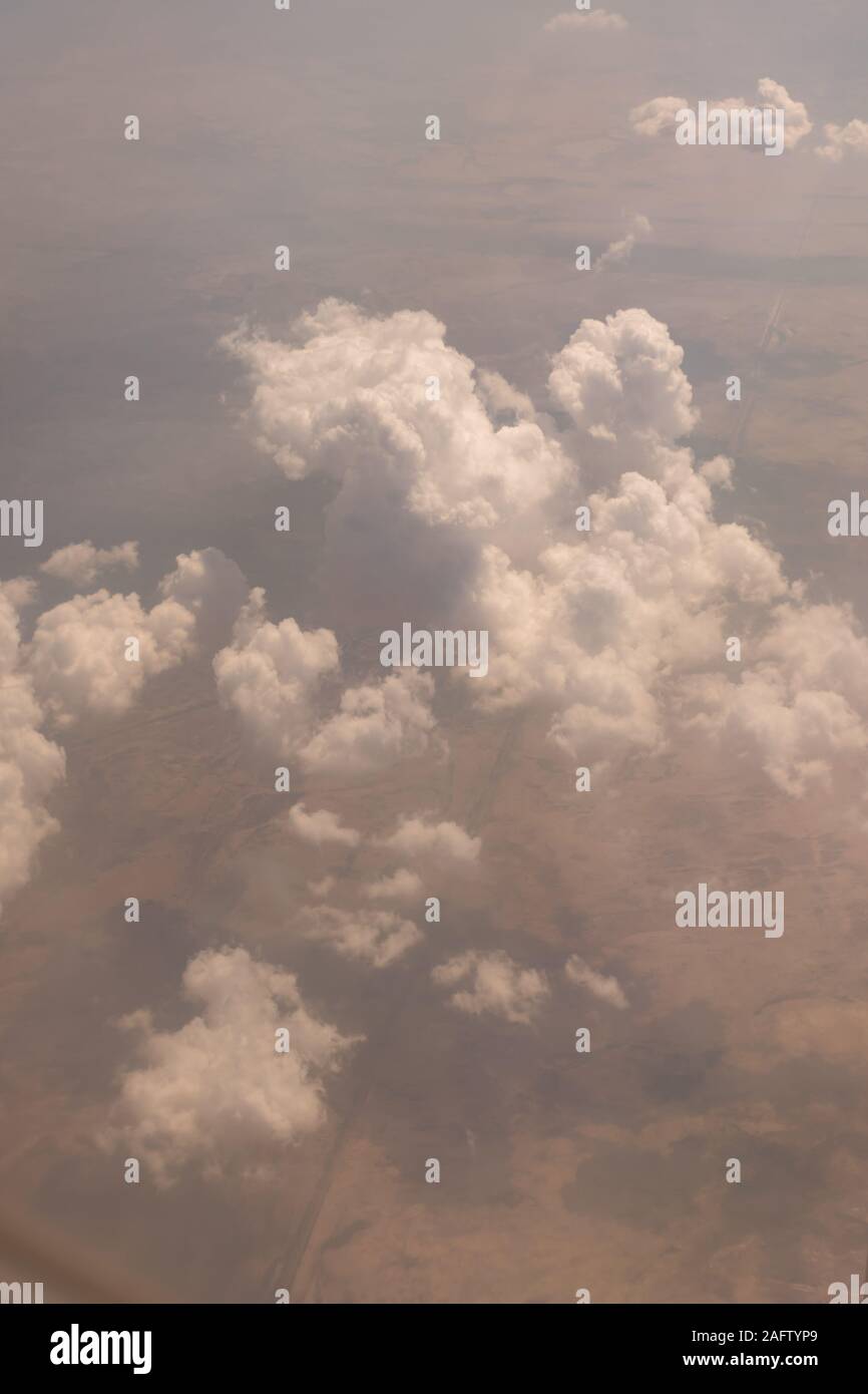 Vista delle nuvole dalla finestra di aeroplano vola ad alta quota che mostra la terra al di sotto di Foto Stock