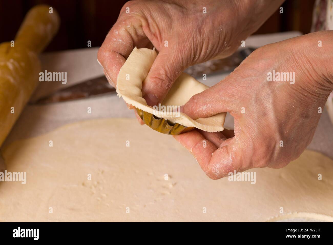 Il processo di cottura di pasticcini. Chiudere fino a mani la cottura in casa sul tavolo da cucina Foto Stock