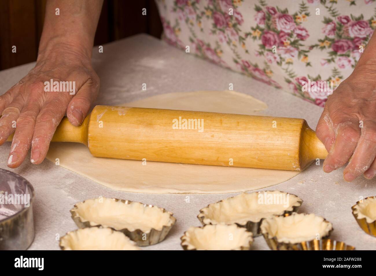 Donna preparare lâ impasto con mattarello su tavola in legno rustico Foto Stock