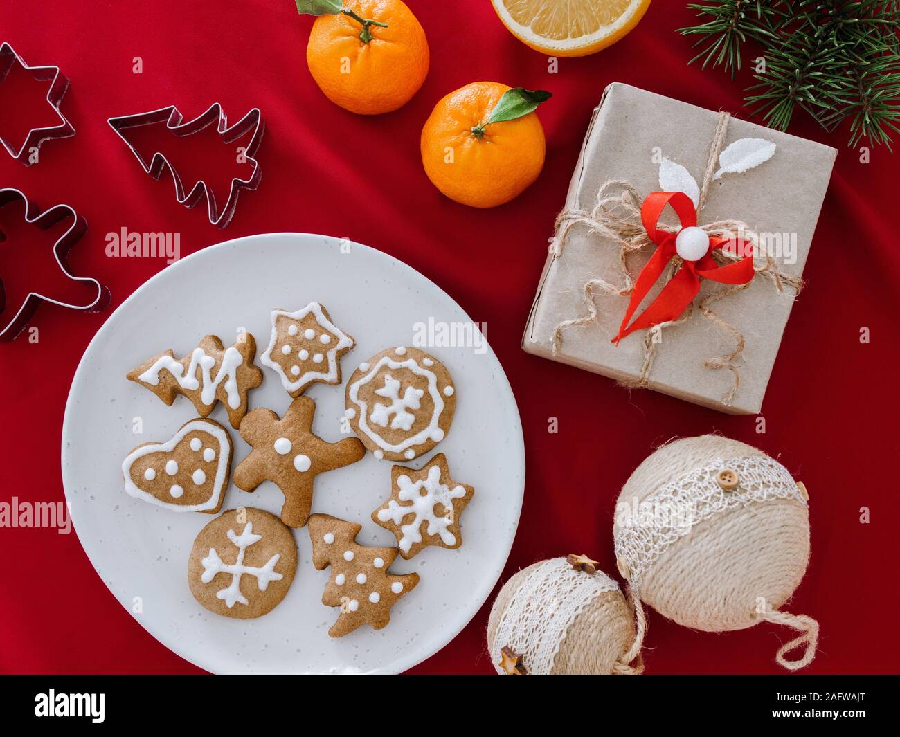 Biscotti a forma di stelle sulla piastra e la mano che tiene. Natale ancora in vita con confezioni regalo e gingerbread cookie, vista dall'alto, sullo sfondo di Natale Foto Stock