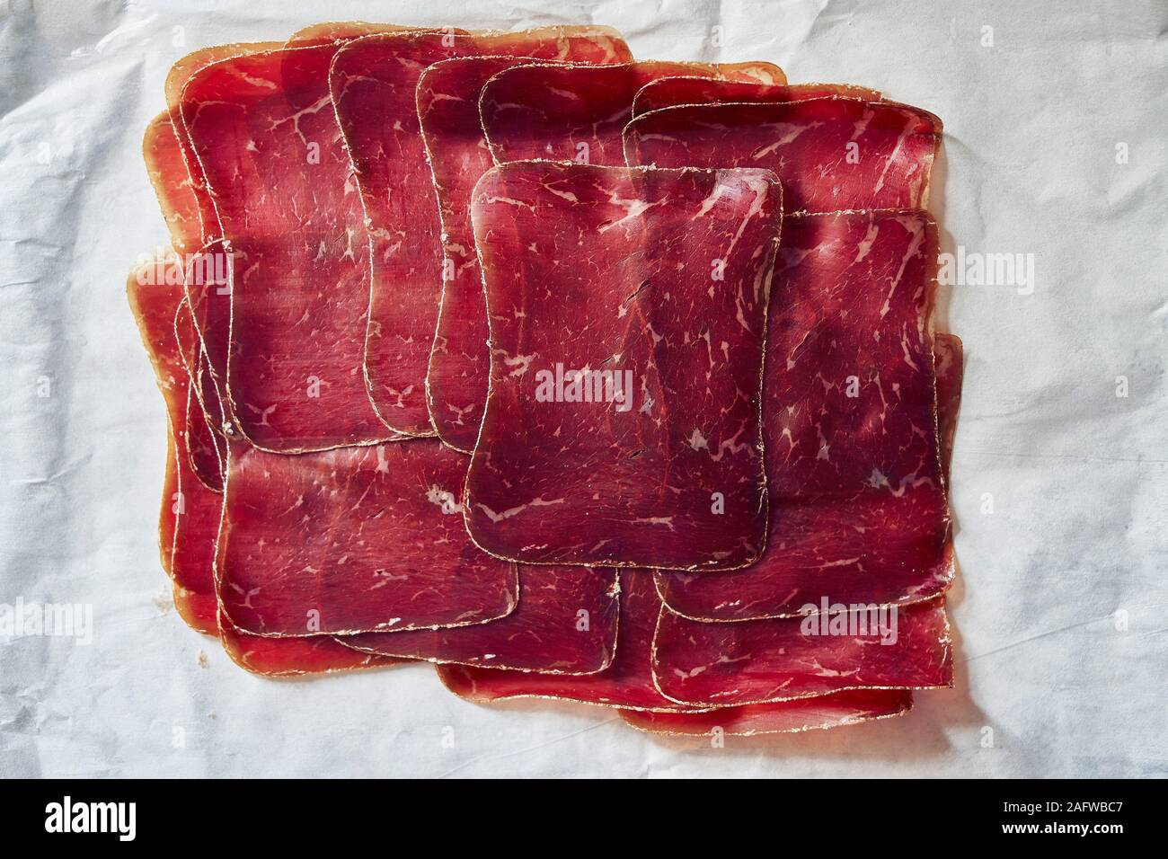 Vista da sopra a fette, aria secca Buendnerfleisch carne sulla carta di macellaio Foto Stock