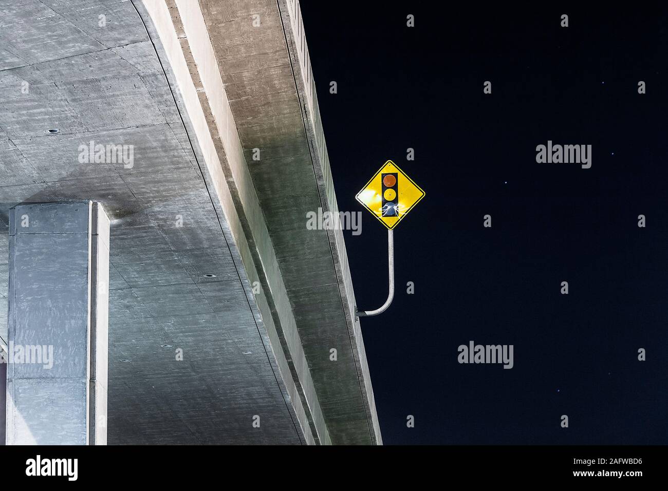 Luce di arresto segno sul ponte dell'autostrada sotto il cielo notturno Foto Stock