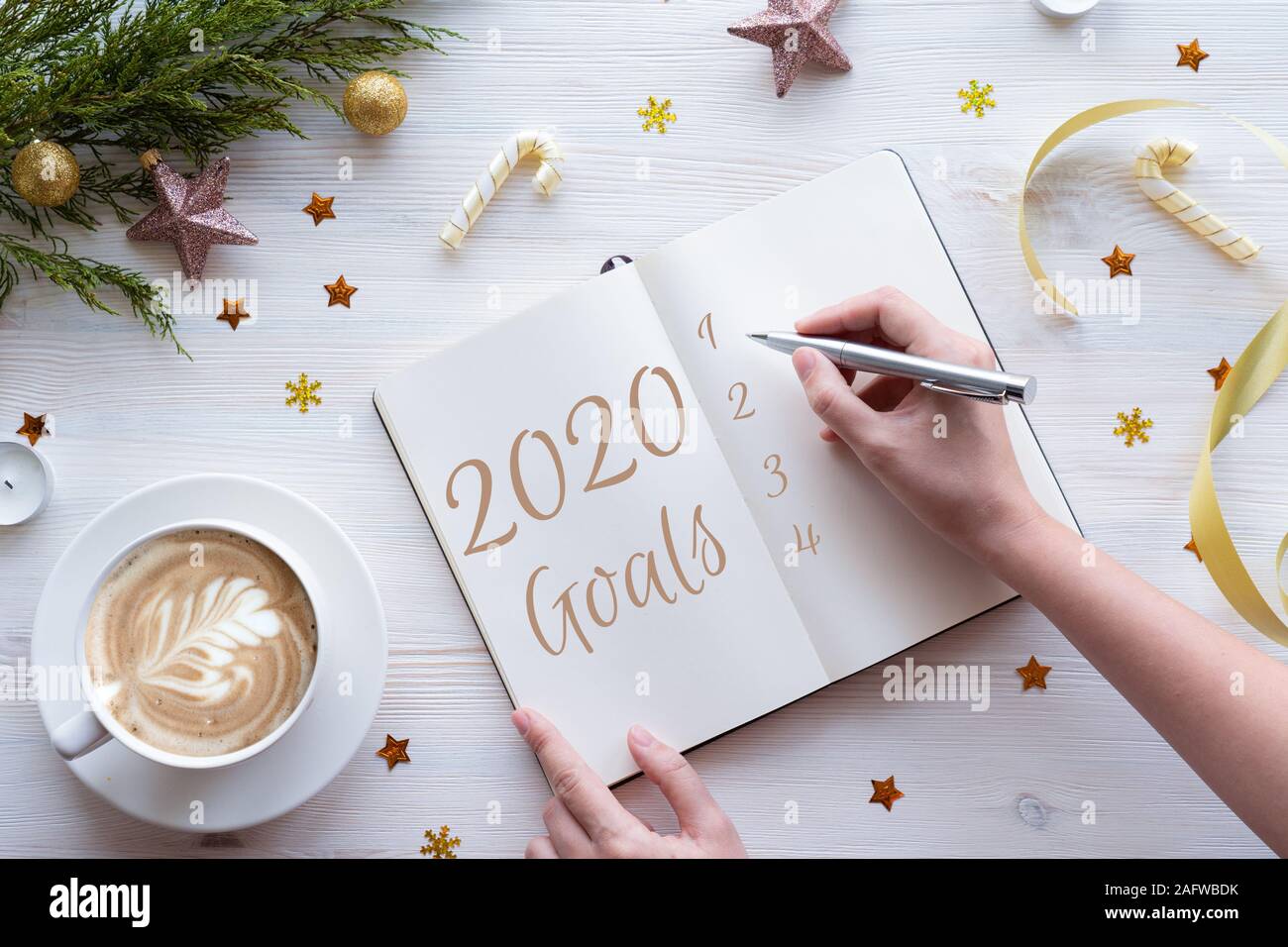 Donna iscritto nel notebook piani obiettivi lista dei desideri per il nuovo anno 2020, laici piatta Foto Stock