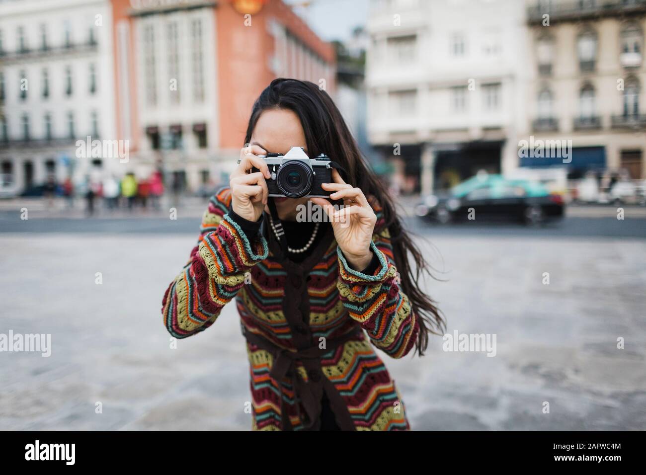 Ritratto turista femminile utilizzando la fotocamera su una strada di città Foto Stock
