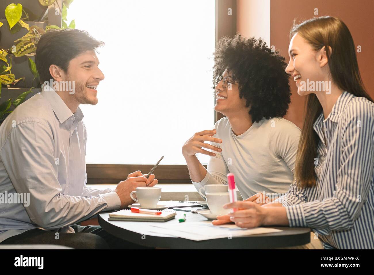 Partner per discutere la strategia durante il pranzo di lavoro nel cafe Foto Stock