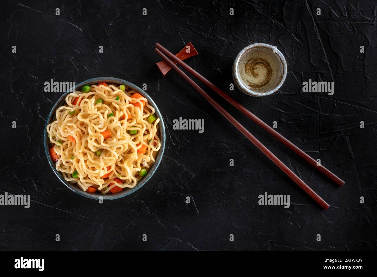 Tagliatelle istante con verdure, con amore e bastoncini, girato dalla parte superiore su uno sfondo scuro con un posto per il testo Foto Stock