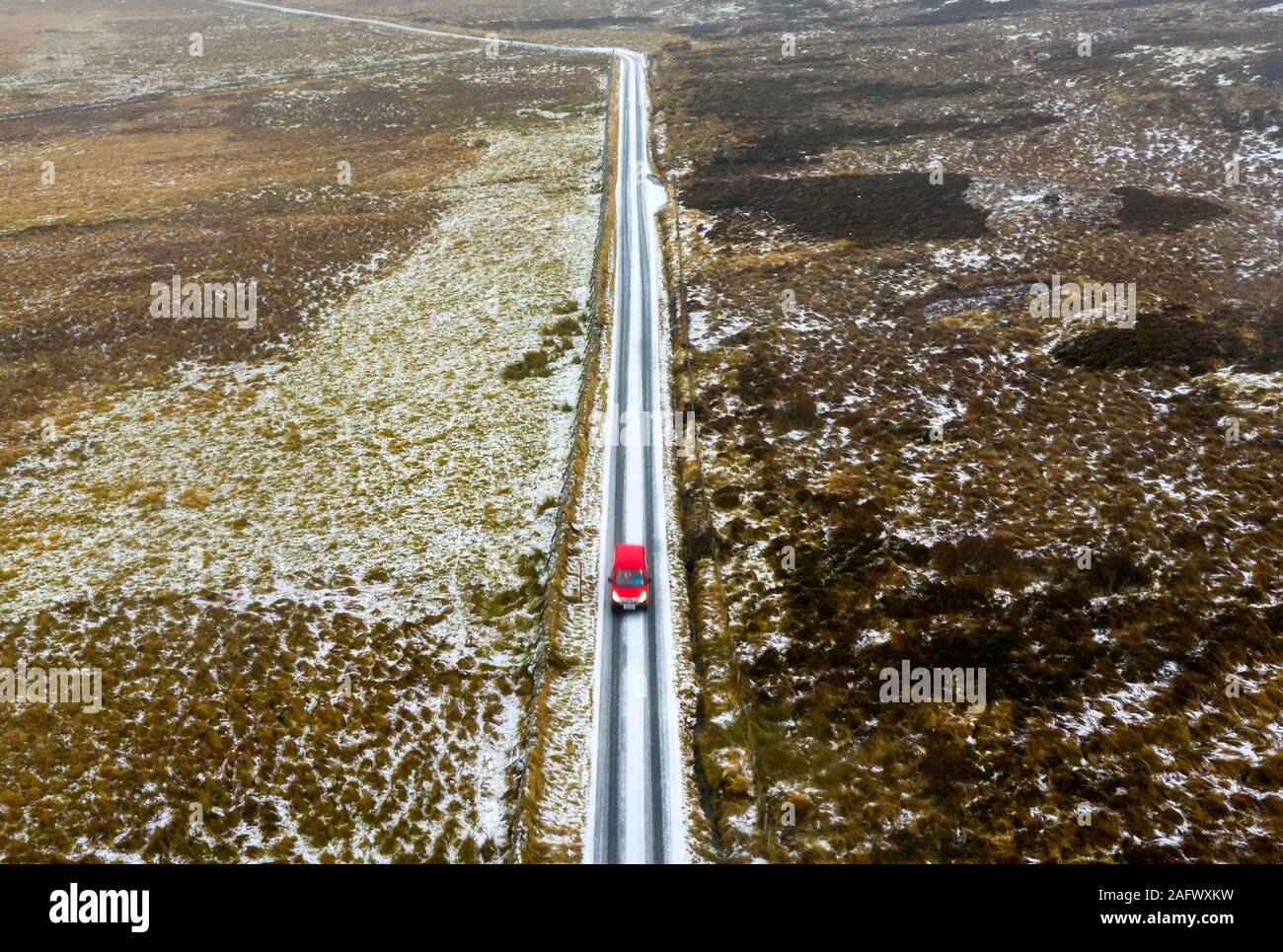 Red Royal Mail post van guida su strade coperte di neve strada rurale attraverso Glen Quaich in Scozia, Regno Unito Foto Stock
