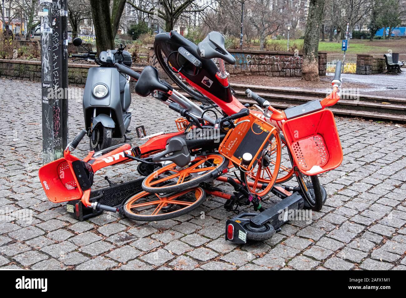 Cittadino di protesta, un mucchio di biciclette e scooter- i berlinesi oggetto per il numero crescente di noleggio di biciclette e scooter sui marciapiedi della città di Berlino Foto Stock