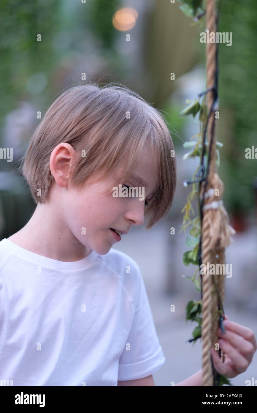 Un bambino è seduta su una oscillazione in un padiglione decorato Foto Stock Un bambino è seduta su una oscillazione in un padiglione decorato Foto Stock
