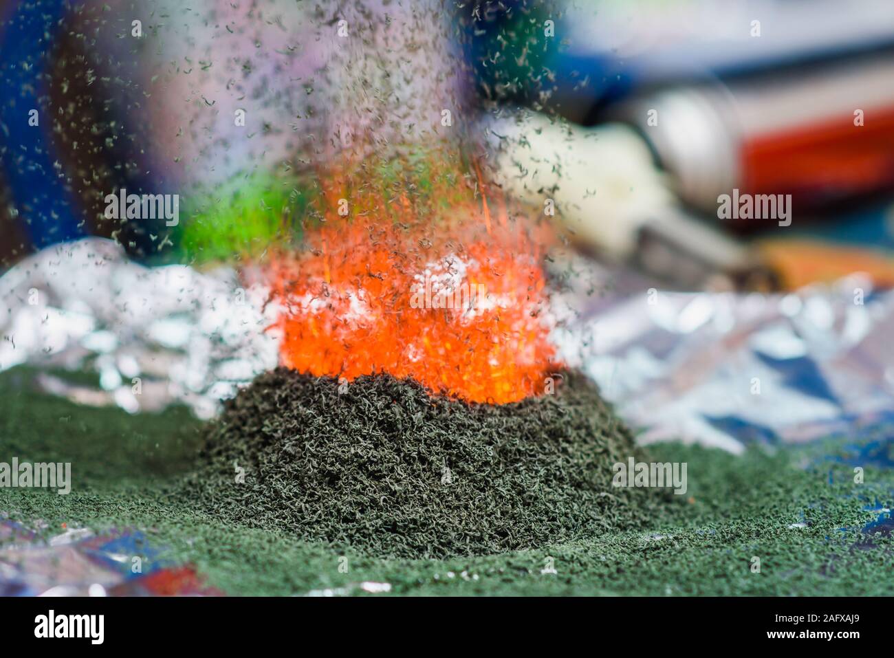 La reazione chimica di dicromato di ammonio se per dare fuoco a esso sulla lamina Foto Stock
