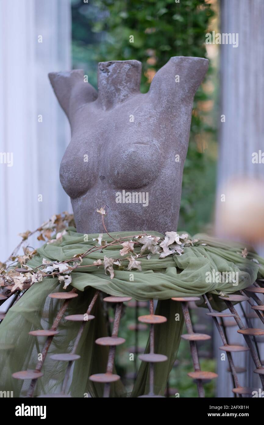 Immagine scultorea di un torso femminile su un supporto metallico in forma di un lussureggiante mantello Foto Stock Immagine scultorea di un torso femminile su un supporto metallico in forma di un lussureggiante mantello Foto Stock