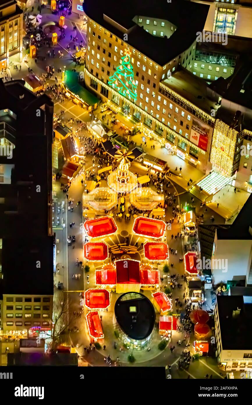 Foto aerea, mercatino di Natale sul Dr-Ruer-Platz, , albero di Natale presso la Sparkasse facciata, dal volo notturno su Bochum, Bochum, Ruhrgebiet, Germania Foto Stock