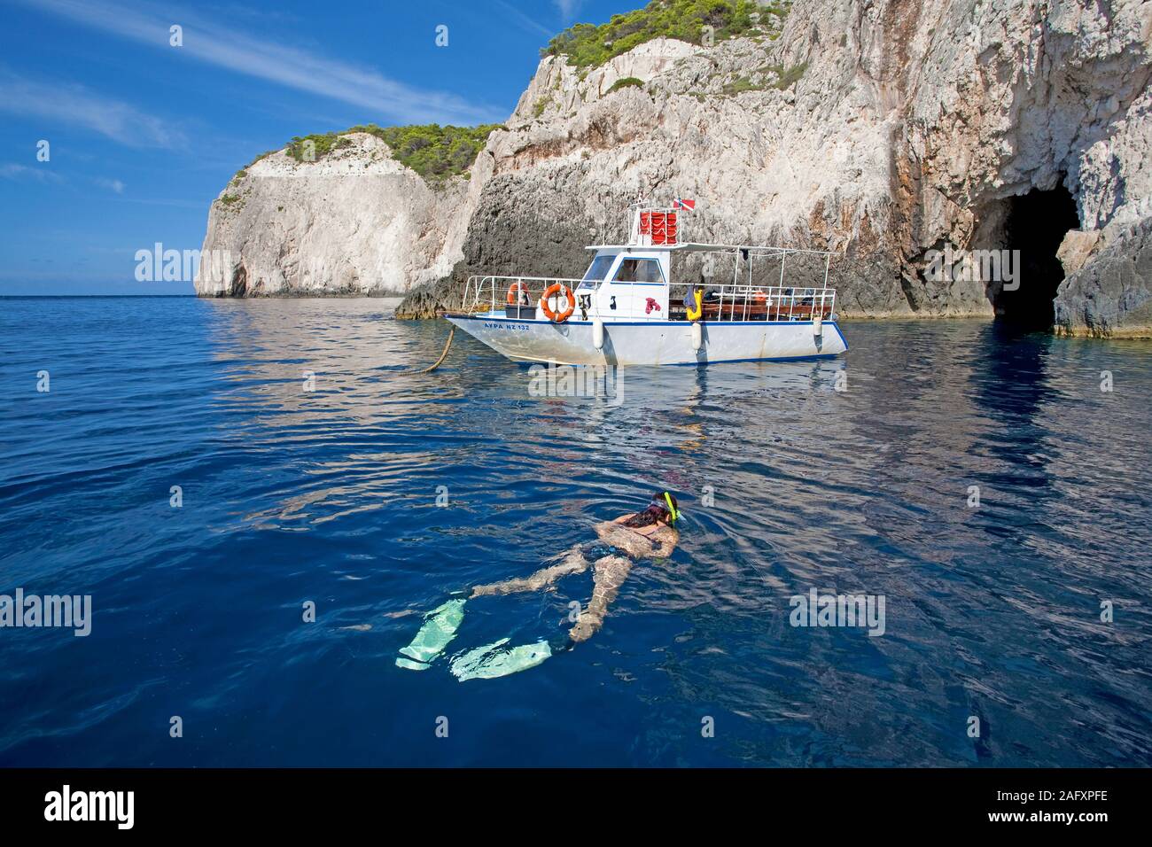 Snorkeller (donna) in barca costa rocciosa dell'isola di Zante, Grecia Foto Stock