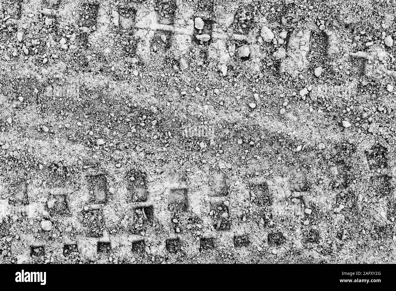 Texture di tracce di pneumatici su terreno asciutto. Sfondo astratti per la progettazione. Monocromatico. Foto Stock