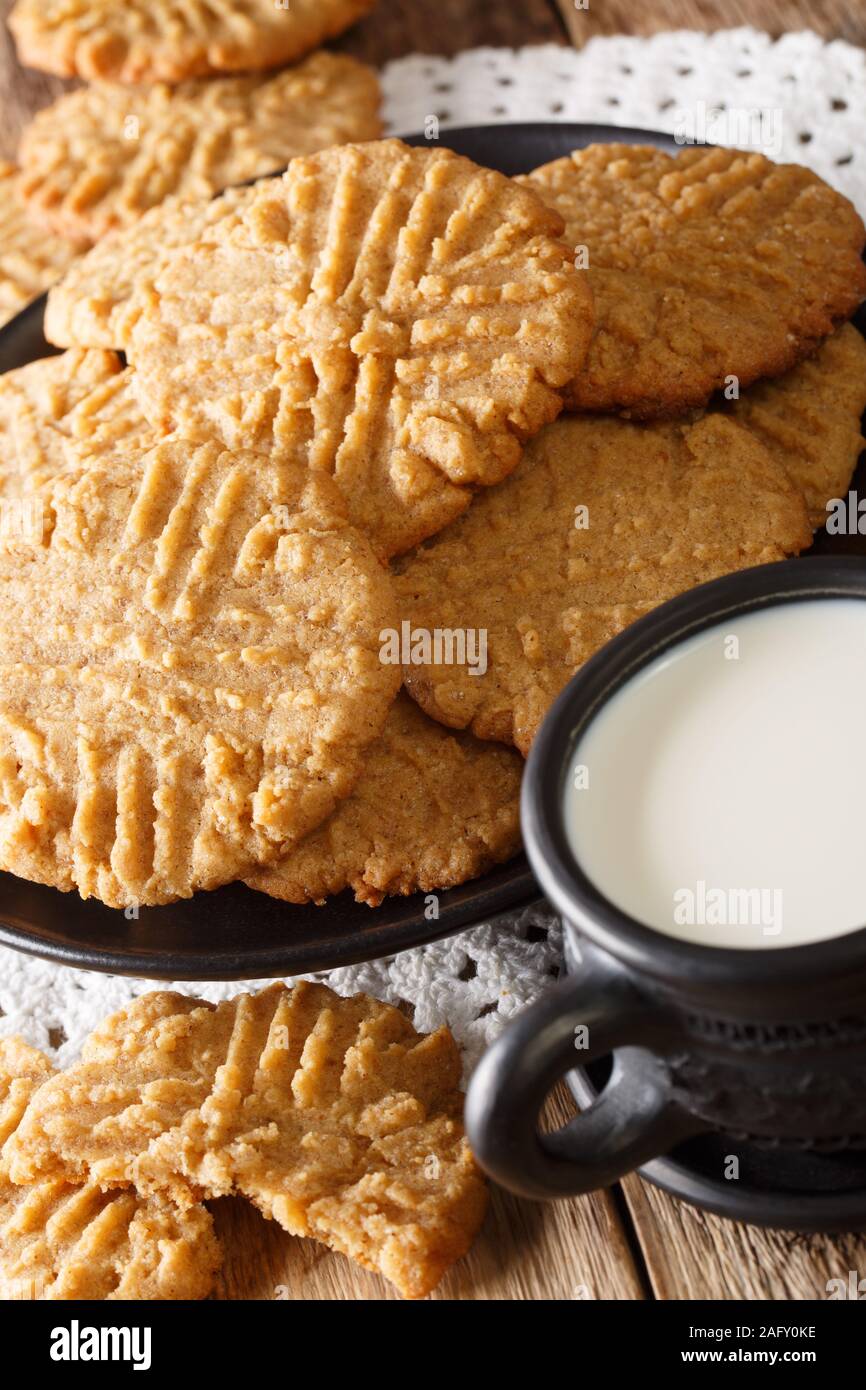 Croccante di burro di arachidi cookie con un bicchiere di latte vicino sul piano verticale. Foto Stock