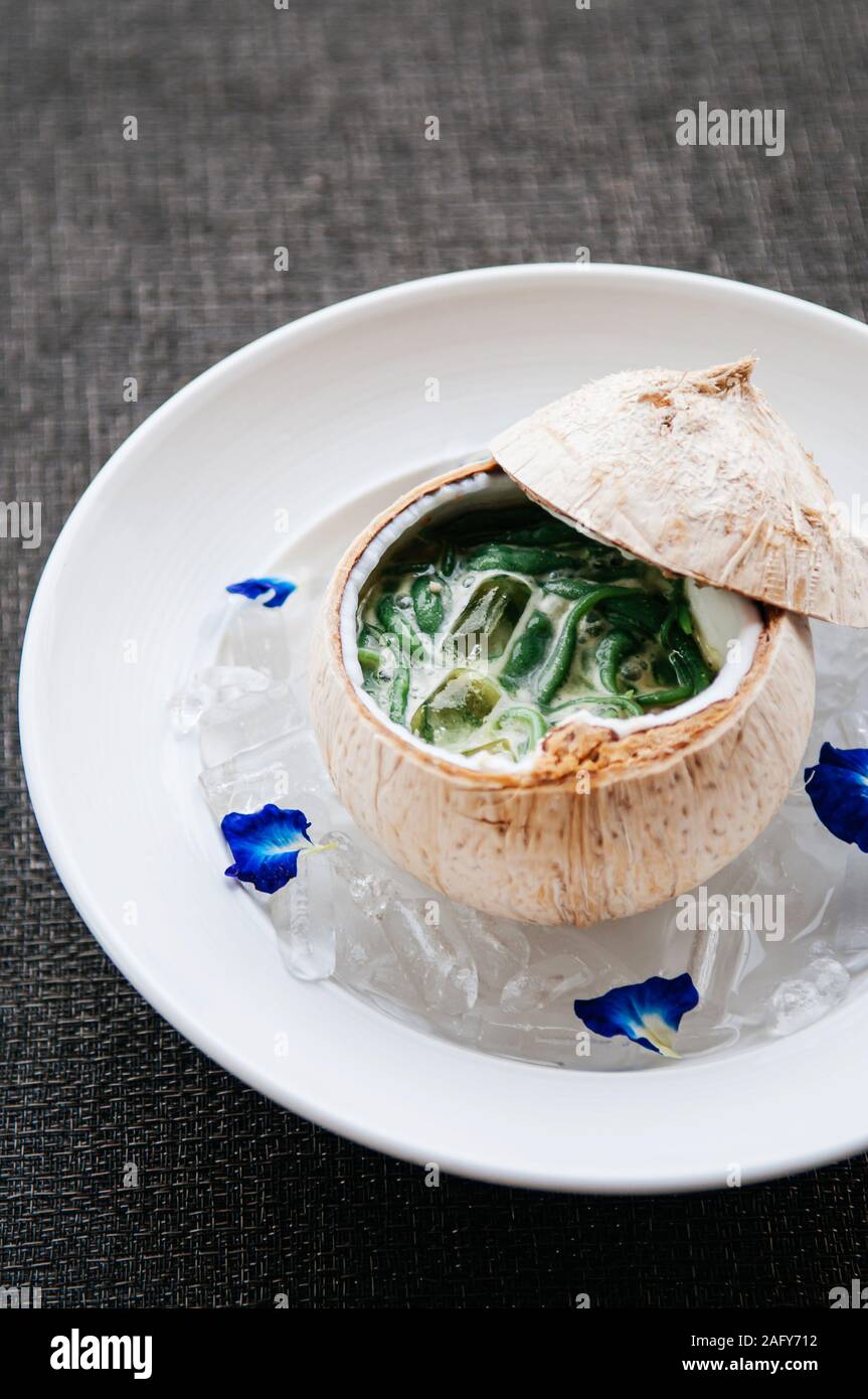 Lod Chong o Cendol, Thailandia e nel sud-est asiatico paese tradizionale a freddo rinfrescante dolce estate dessert con latte di cocco servita nel guscio di noce di cocco Foto Stock