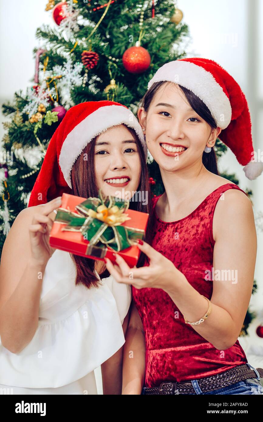 Due ragazze asiatiche teen in felicità Natale Capodanno momento cellebration presente confezione regalo colpo verticale. Foto Stock