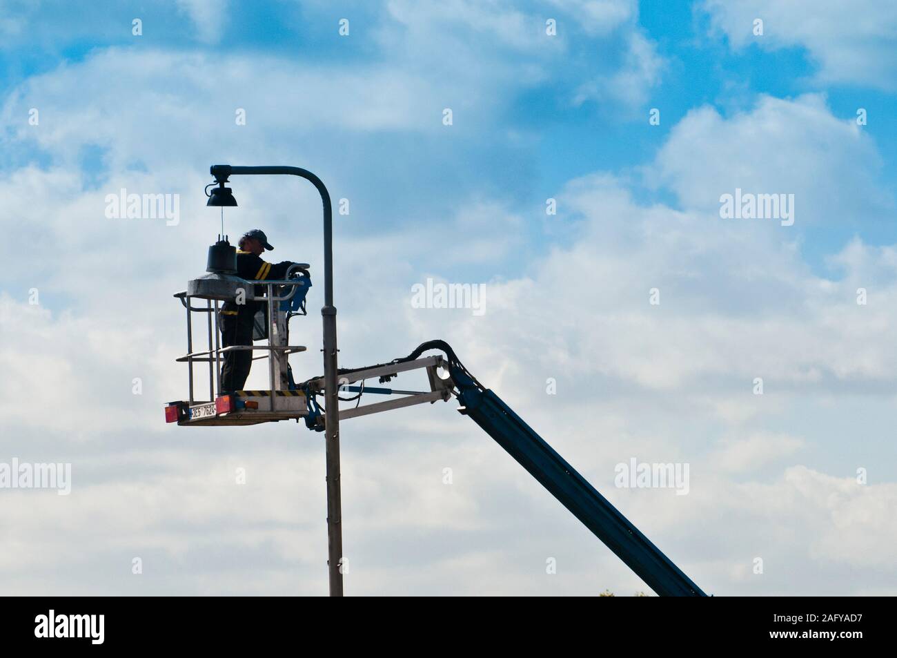 Street lavoratore di manutenzione riparazione di un lampione Foto Stock