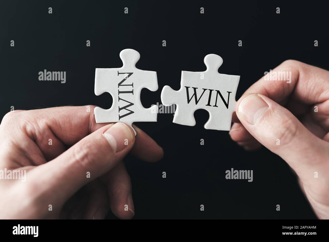Win win situation concetto con mani tenendo i pezzi del puzzle Foto Stock