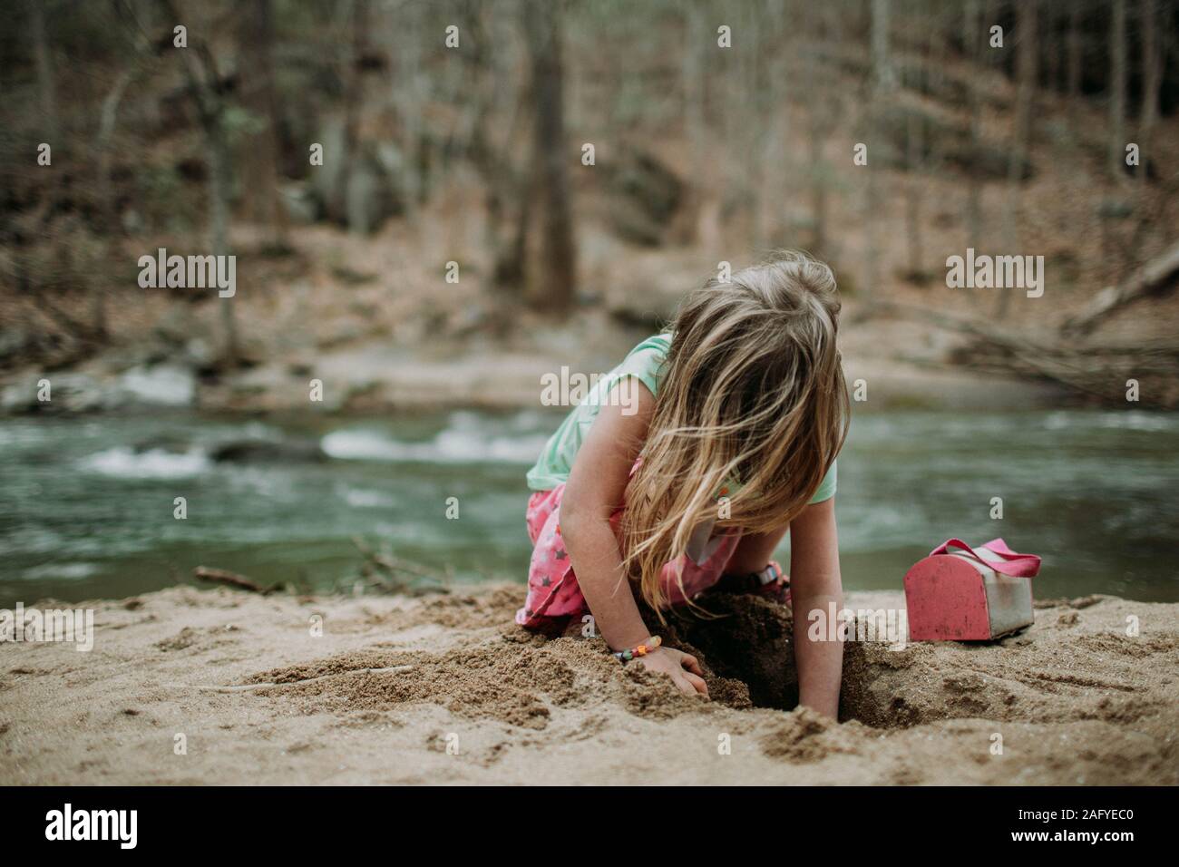 Volto Ritratto di giovane ragazza il riverbank giocando nella sabbia Foto Stock