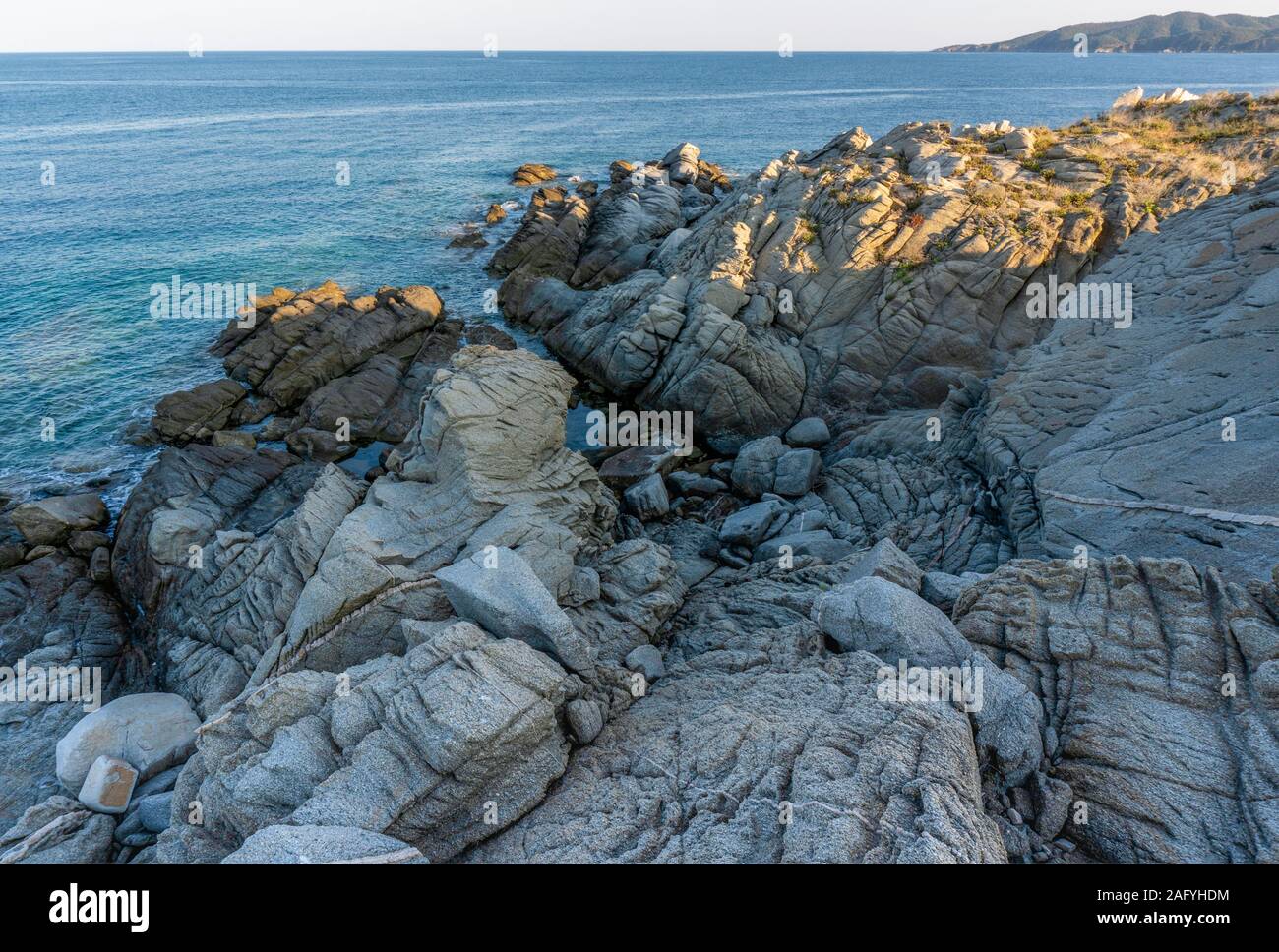 Il mare e le pietre grigie in Grecia in orizzontale Foto Stock