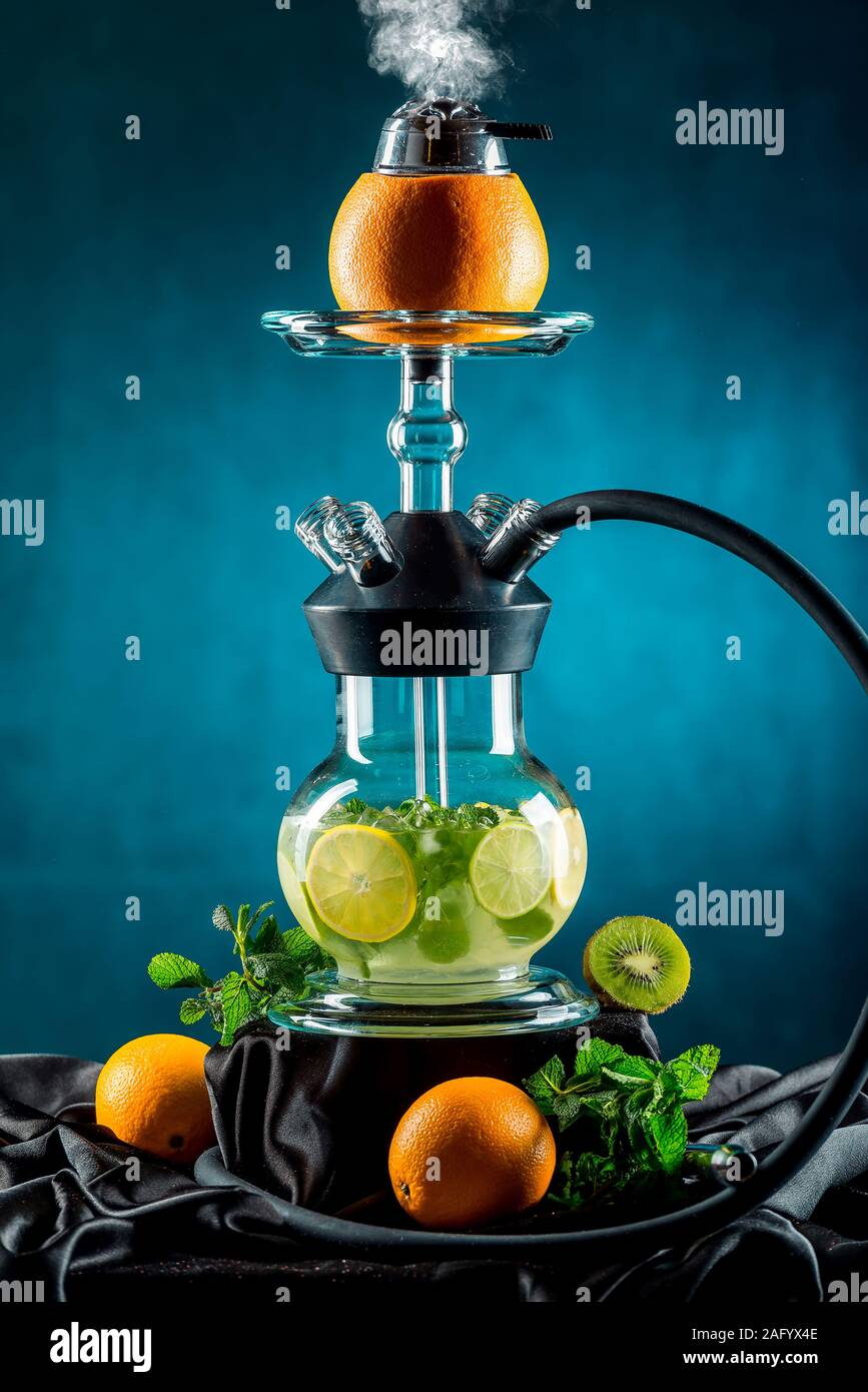 Aroma di frutta Hookah isolati su sfondo nero contro uno sfondo scuro con fumo Foto Stock