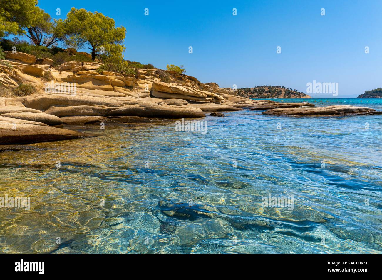 Alberi che crescono sulle rocce e mare in Grecia in orizzontale Foto Stock