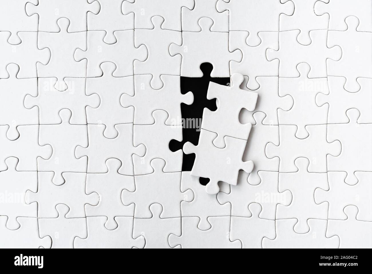 White blank jigsaw puzzle con due pezzi di un puzzle prelevato Foto Stock