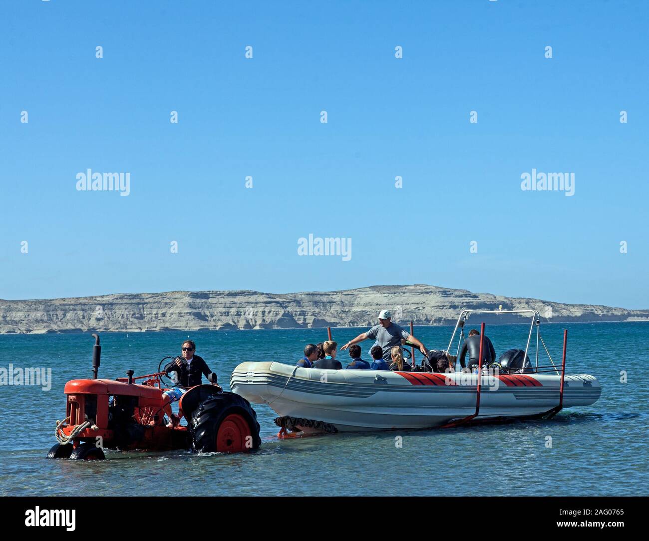 Trattore tirando dinghy in mare Foto Stock