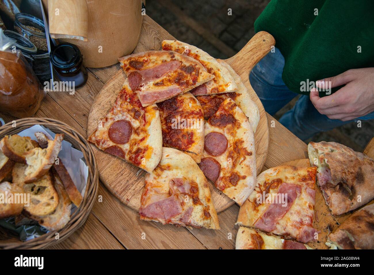 La pancetta e salsiccia per pizza, pomodoro, formaggio croccante pitsa calda in vendita presso un fornitore,s contatore. Foto Stock