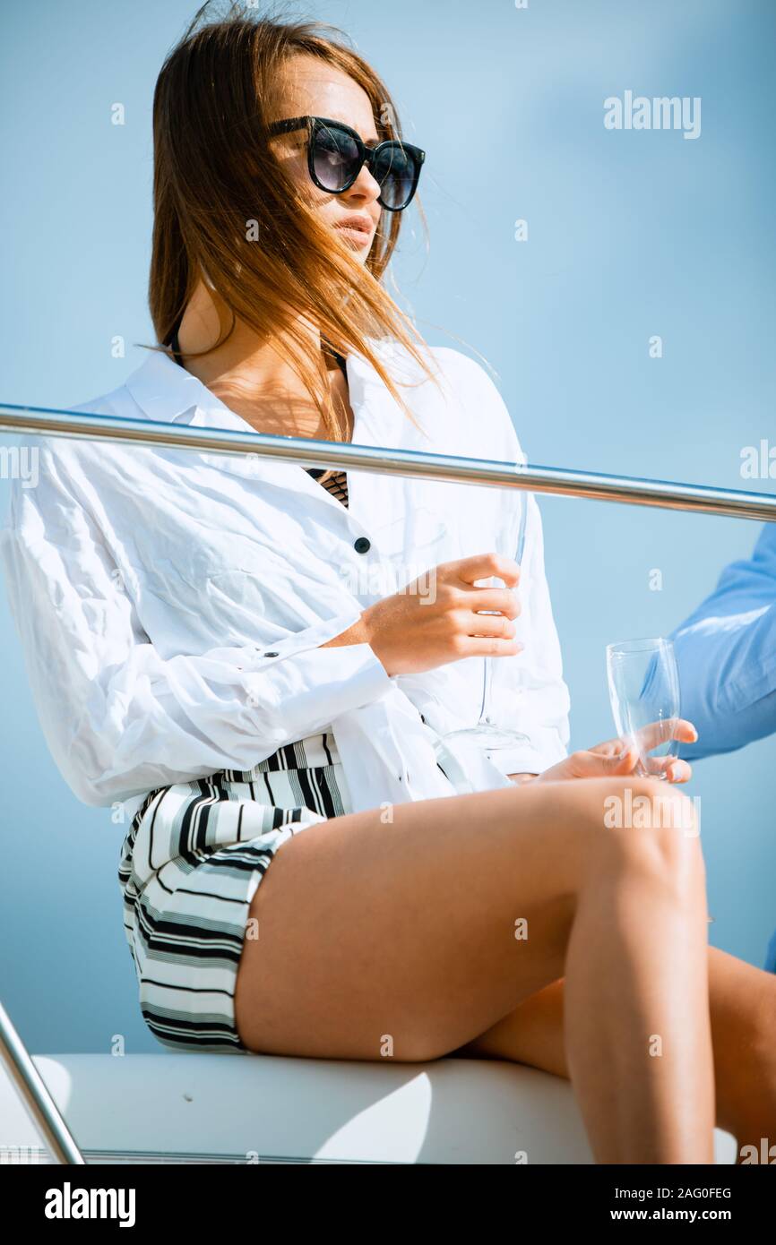 Donna su yacht con il bicchiere di champagne avente divertente durante la gita in mare. Foto Stock