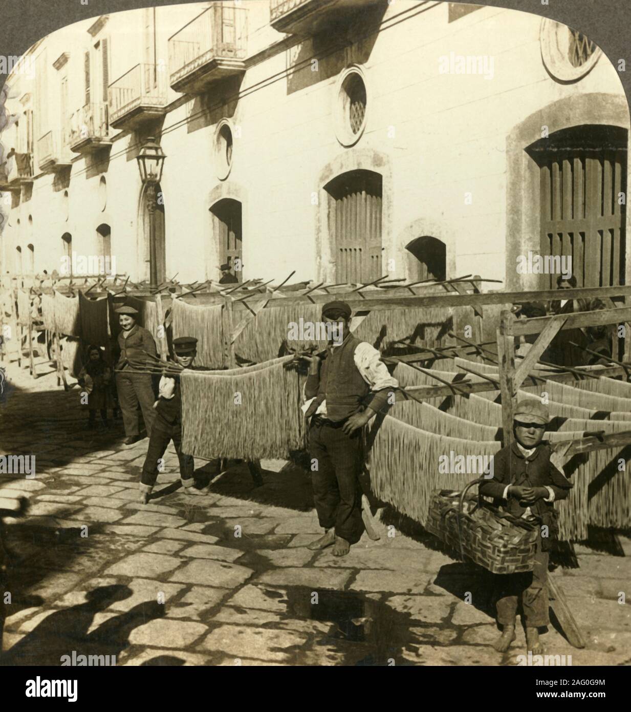 'Macaroni essiccazione nella strade sporche di napoli, Italia', C1909. La pasta deve essere rapidamente stabiliti o appesi ad asciugare non appena si arriva attraverso la macchina o come esso&#x2019;s laminato e tagliato, essiccazione è la più difficile e critica fase di controllo nella pasta del processo di produzione. Per essere visualizzati su un Sun stereoscopio scultura realizzata da Underwood &AMP; Underwood. [Rose Stereografia Company, Melbourne, Sydney, Wellington &AMP; Londra, c1909] Foto Stock