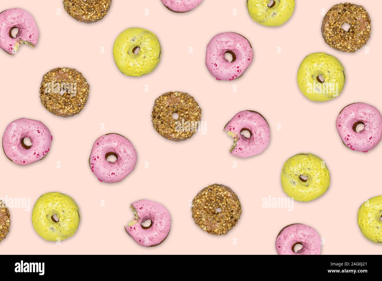 Ciambelle multicolore che cade contro il sfondo rosa. Foto Stock
