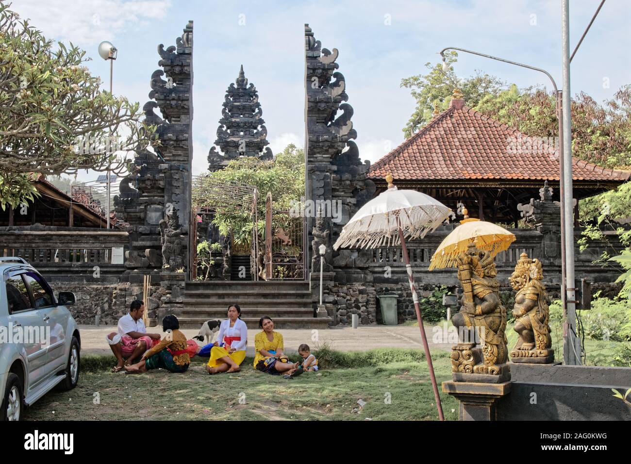 Famiglia Balinese del tempo di qualità nel pomeriggio accanto alla pura Tanjung Sari entrata Foto Stock