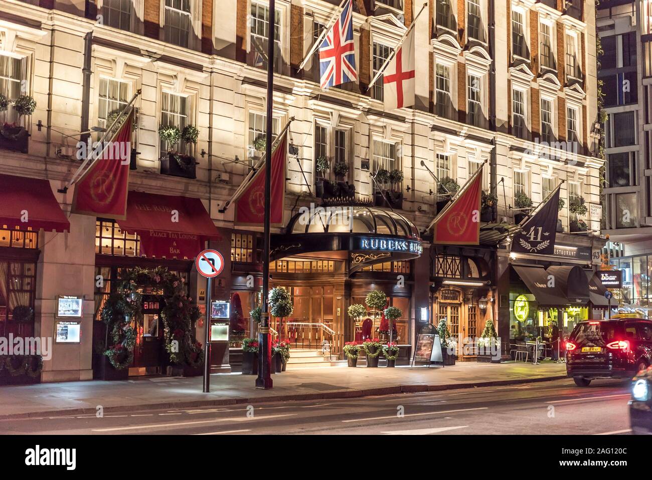 Ingresso grande, facciata frontale, vista serale della strada di Rubens al Palace Hotel, 39 Buckingham Palace Road, Westminster, Londra UK illuminato di notte Foto Stock