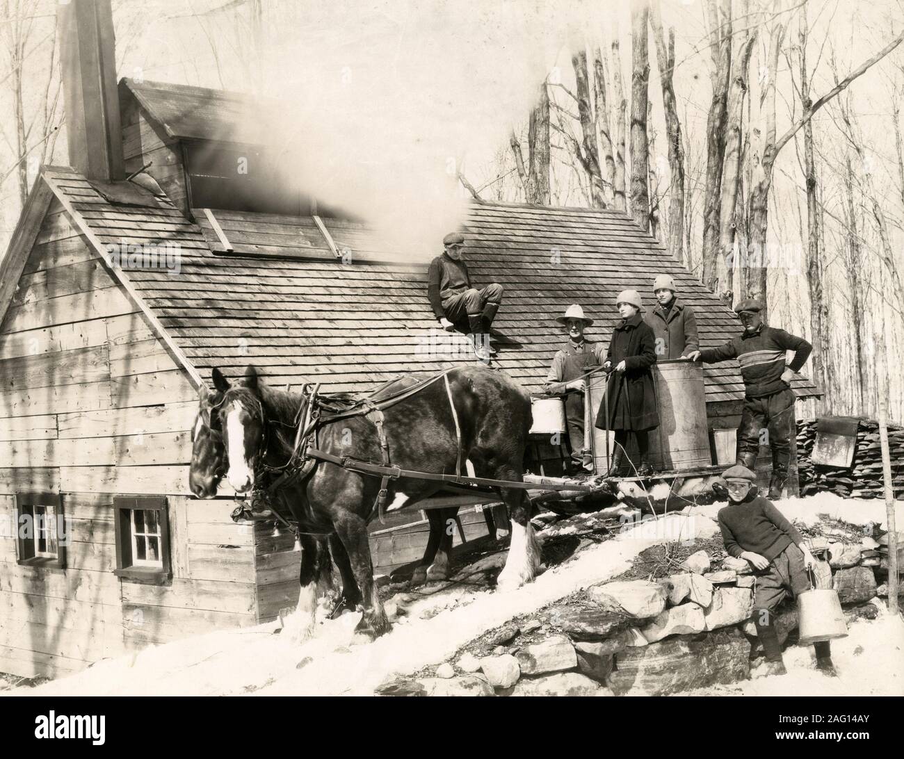 Nei primi anni del XX secolo vintage premere fotografia - rendendo lo sciroppo d'acero in una fattoria in Canada nella neve Foto Stock