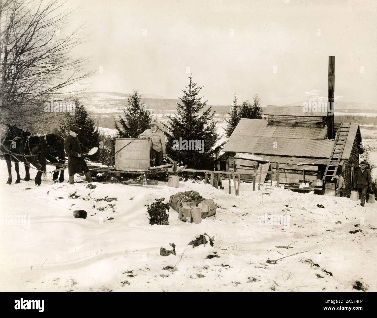 Nei primi anni del XX secolo vintage premere fotografia - rendendo lo sciroppo d'acero in una fattoria in Canada nella neve Foto Stock