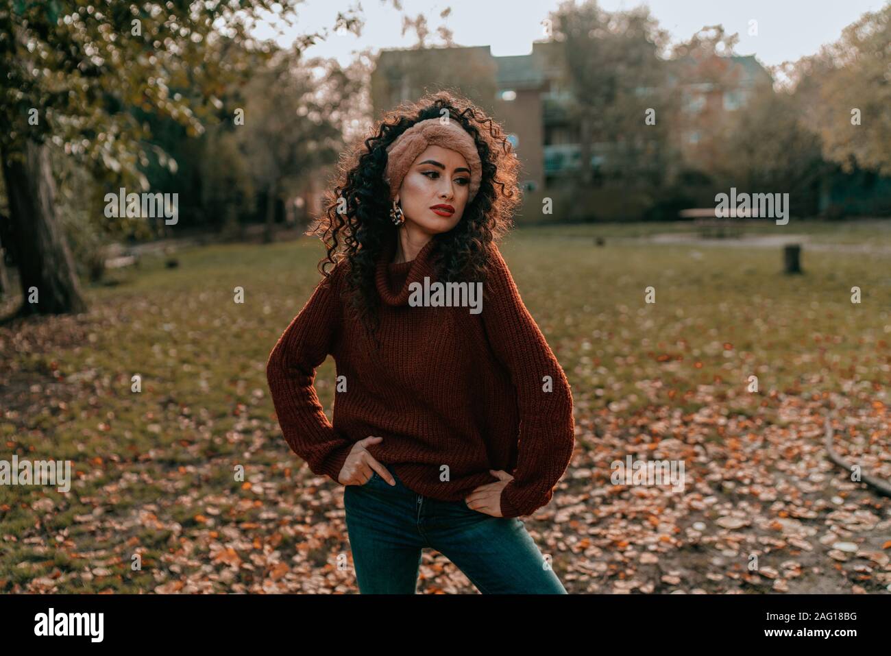 Ritratto di giovane bruna ragazza con i capelli ricci, Fashion Street Style, ponendo all'aperto Foto Stock