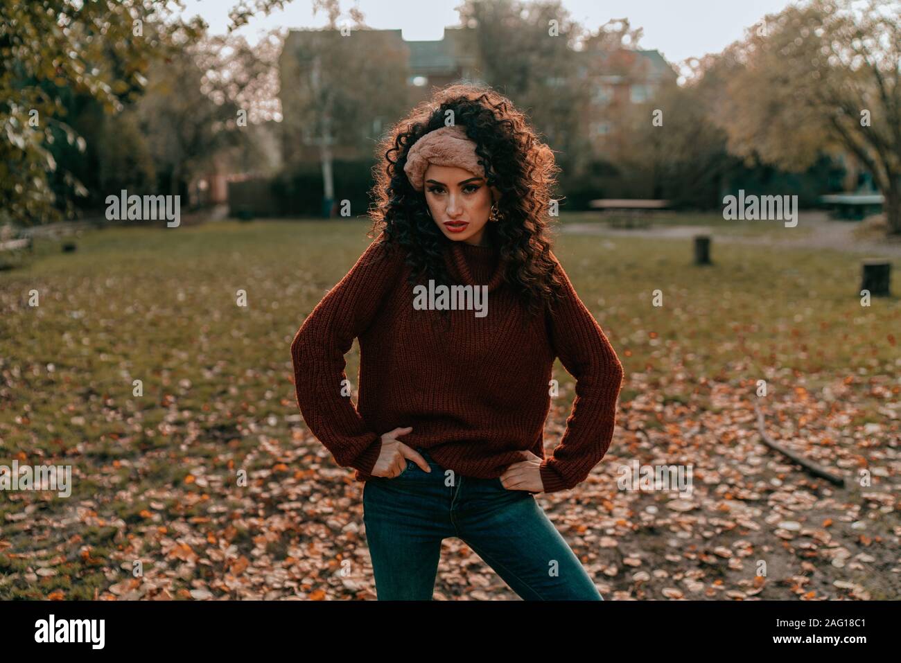 Ritratto di giovane bruna ragazza con i capelli ricci, Fashion Street Style, ponendo all'aperto Foto Stock