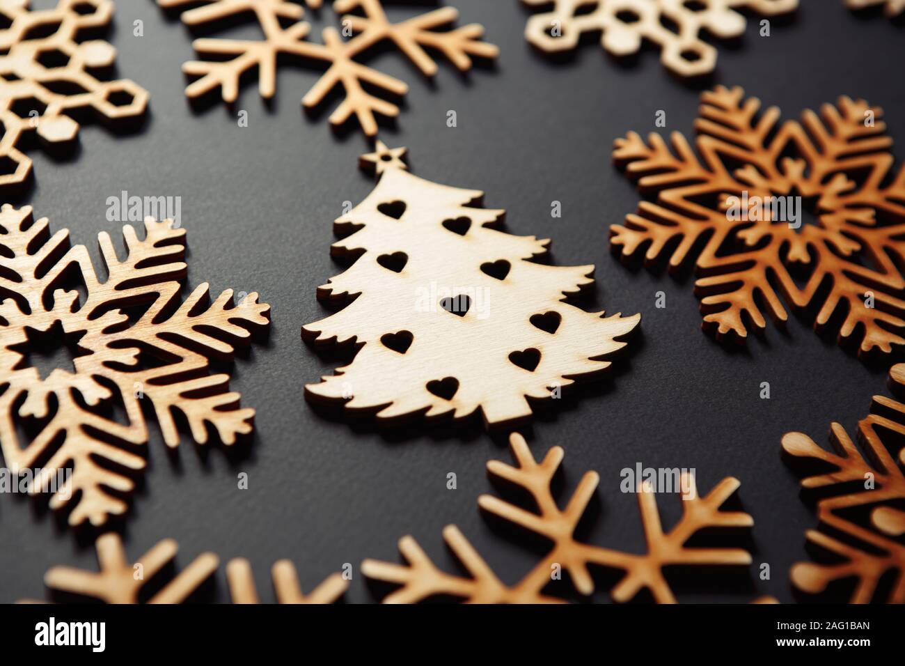 Rustico albero di Natale giocattoli su sfondo nero.bella mano di elementi in legno realizzato a partire da materiale ecologico per la casa decor. Foto Stock