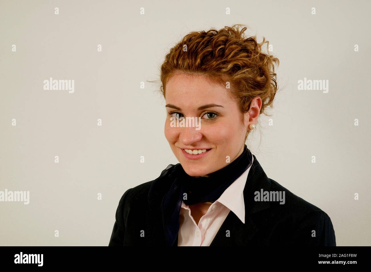 Giovane donna sorridente e guardando la telecamera. Foto Stock
