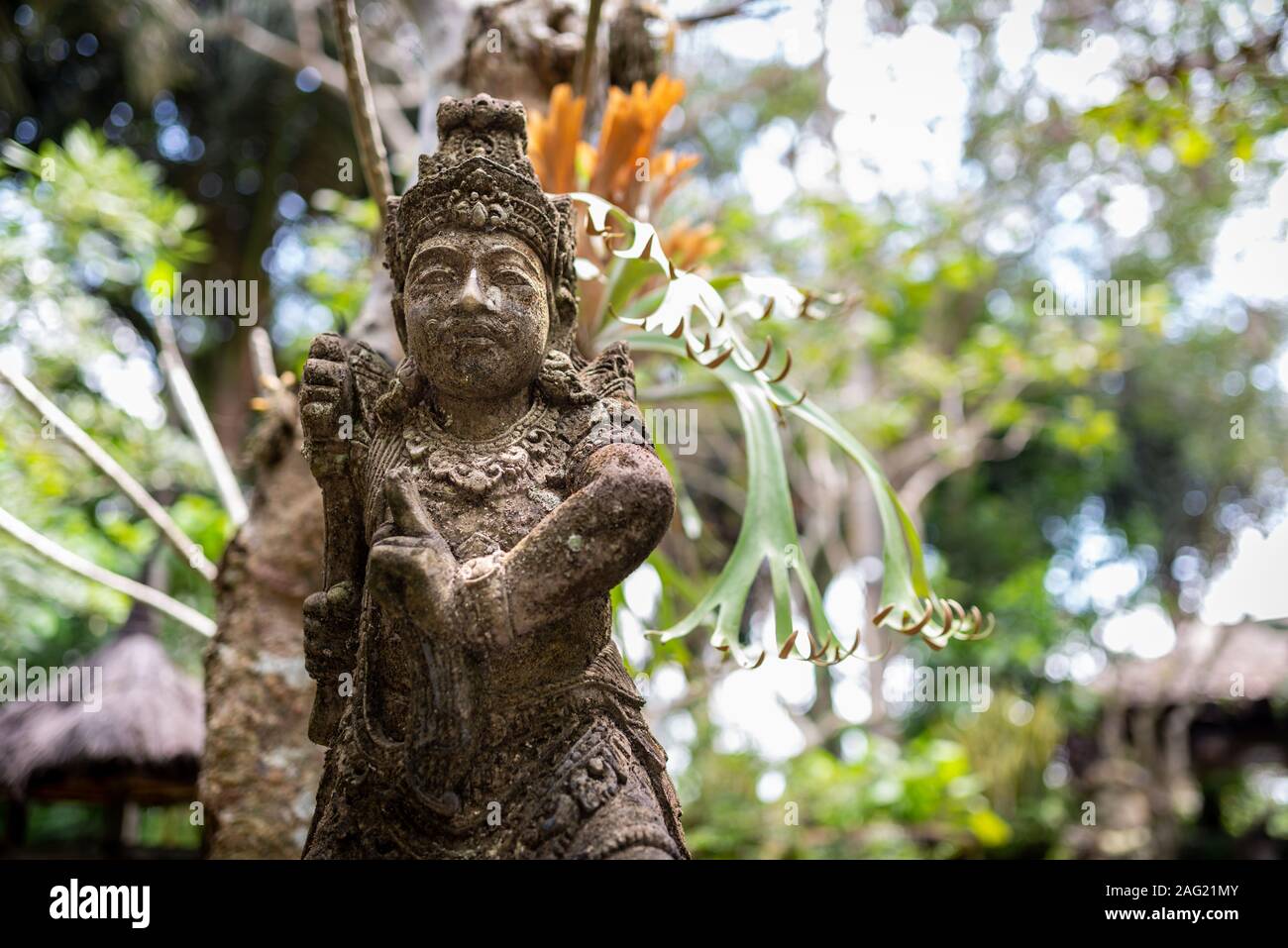 Statua di un guerriero e sfocata sullo sfondo di vegetazione, presa su un pomeriggio nuvoloso, Ubud, Bali, Indonesia Foto Stock