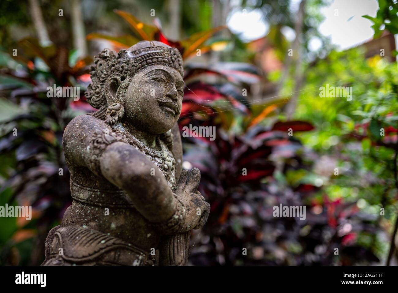 Statua di un guerriero e sfocata sullo sfondo di vegetazione, presa su un pomeriggio nuvoloso, Ubud, Bali, Indonesia Foto Stock